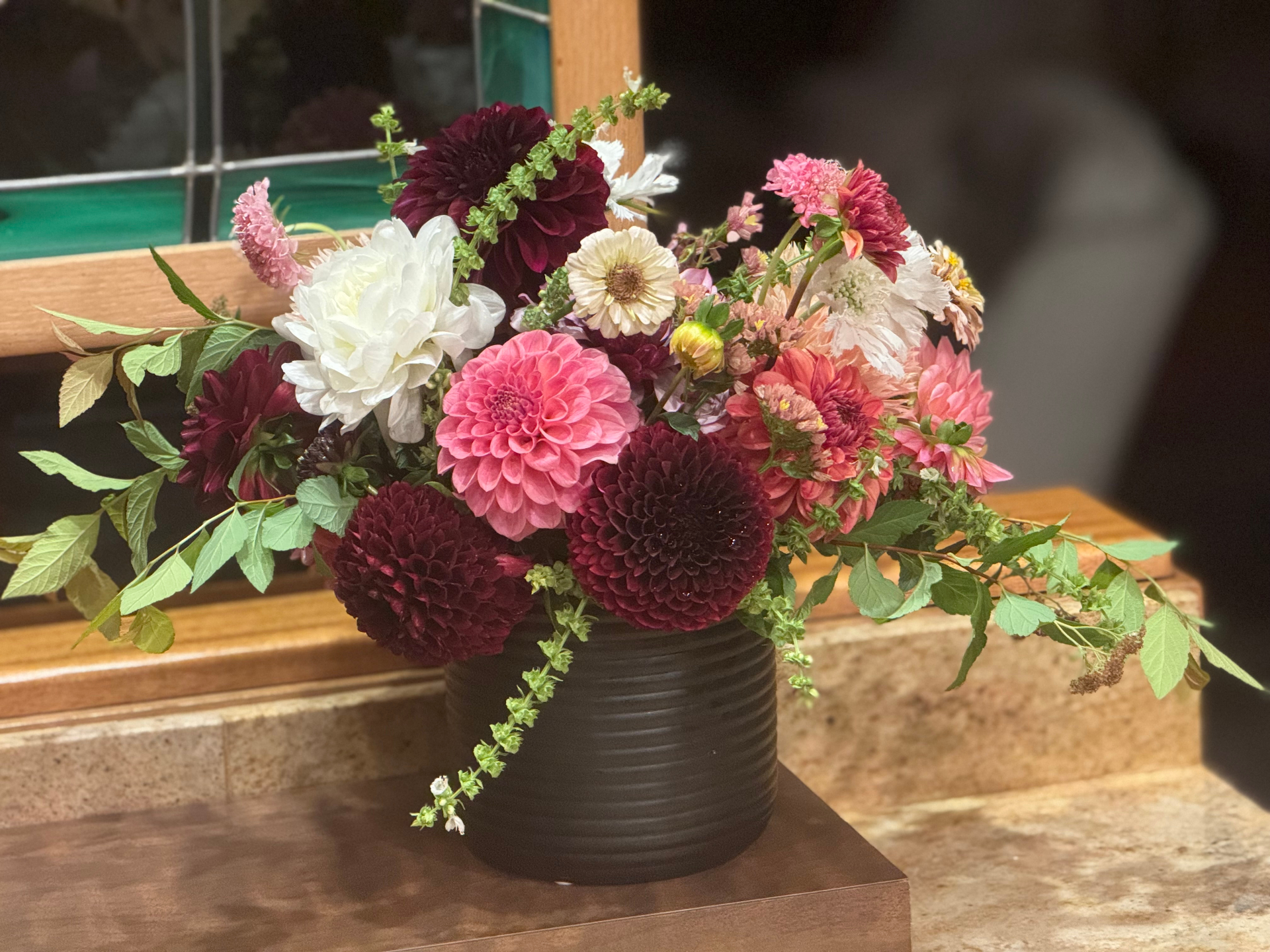 Hand-tied dahlia arrangement in a black ceramic vase